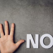 word-no-with-child-s-hand-dark-wall